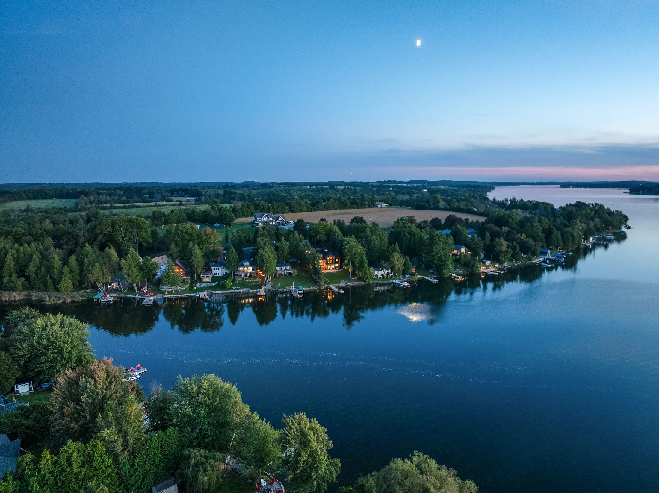 Twilight aerial view of lakefront properties in Deerhurst, Ontario, captured by NH Media drone photography.
