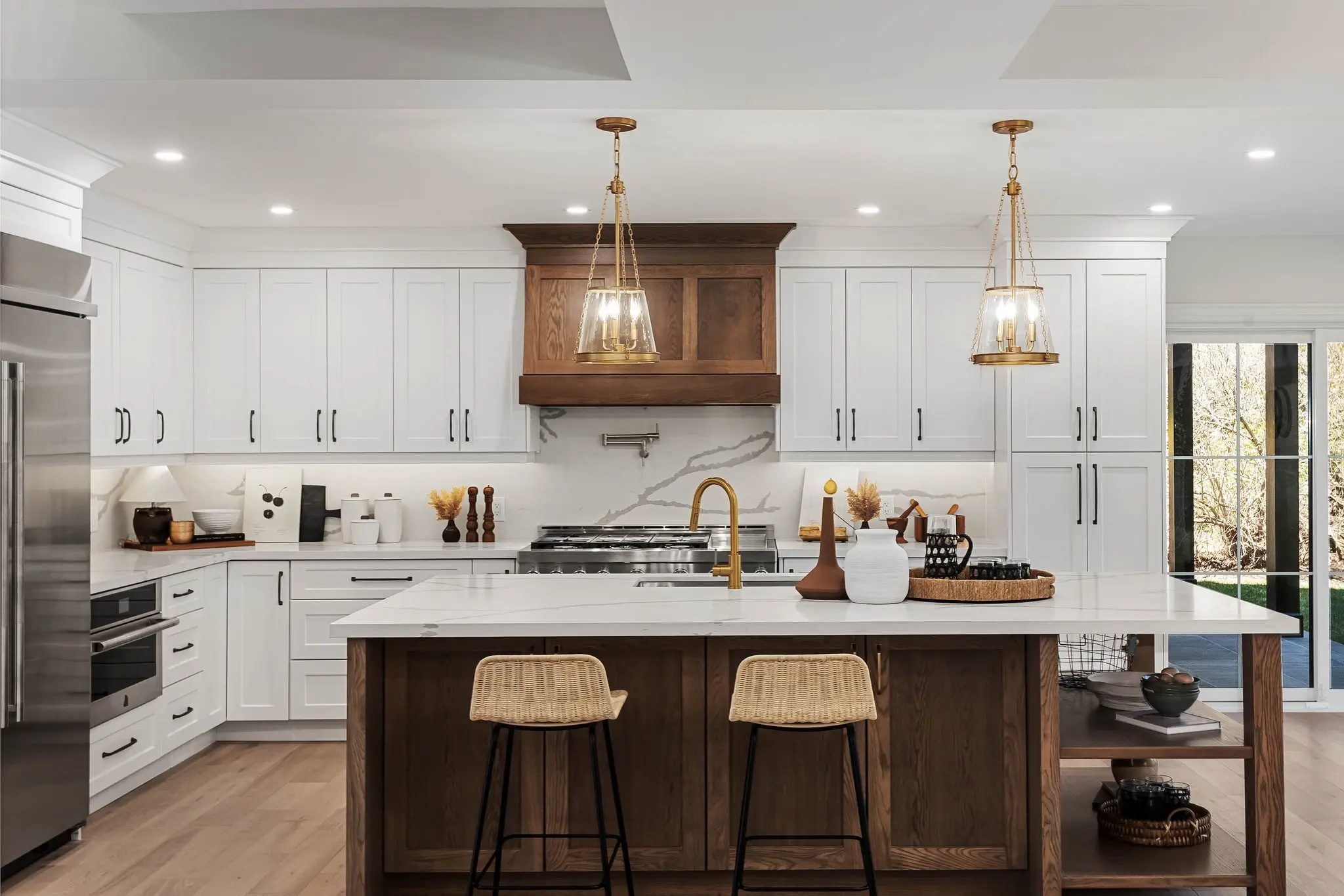 Detailed interior photography of a custom Oshawa kitchen featuring white shaker cabinets, a dark wood island, and brass pendant lighting.