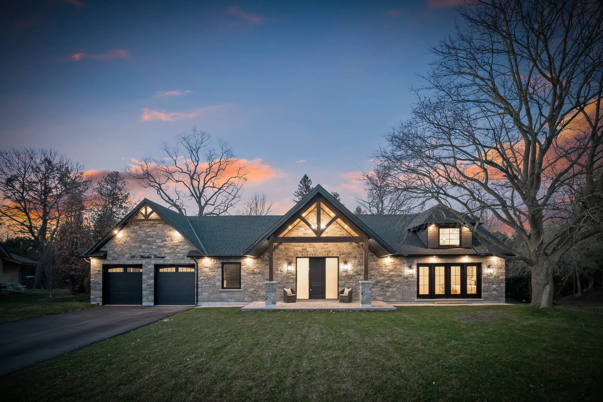 Twilight architectural photography of a custom stone-exterior home in Whitby, highlighting warm lighting and detailed craftsmanship.